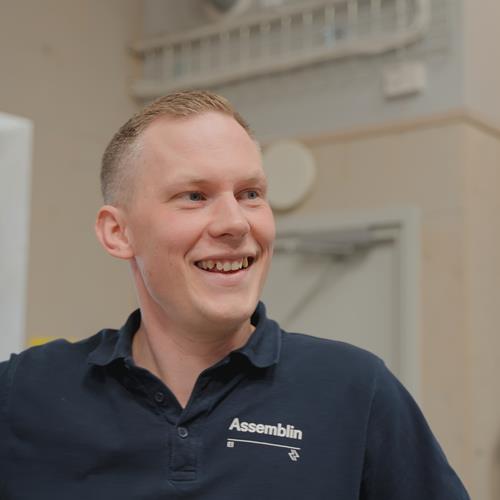 Manlig Assemblinklädd man som ler