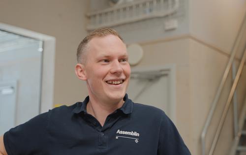 Manlig Assemblinklädd man som ler