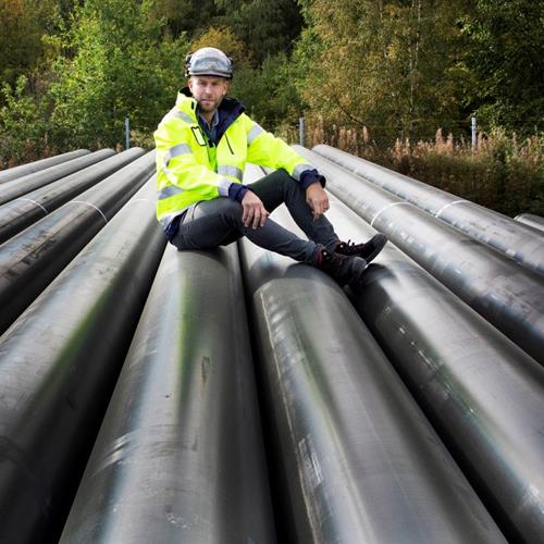 Man tittar mot kameran i gula arbetskläder